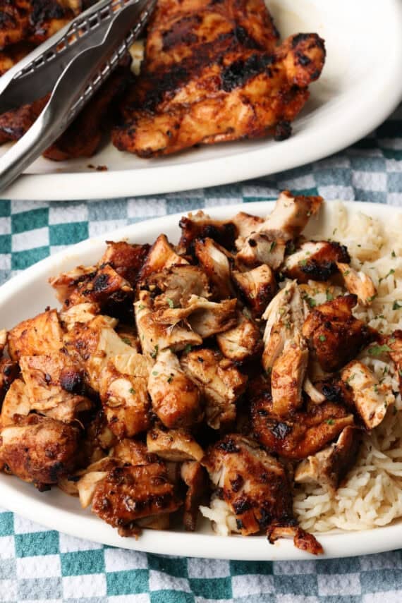 Chopped Chipotle chicken served next to rice on a plate, with more chicken on a second plate in the background.