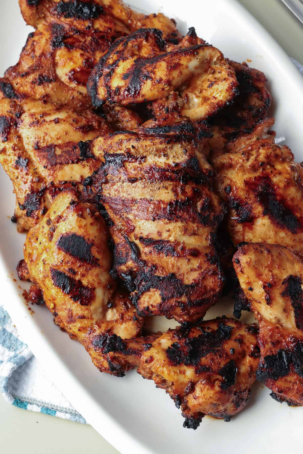 Overhead view of grilled Chipotle chicken thighs on a serving platter.