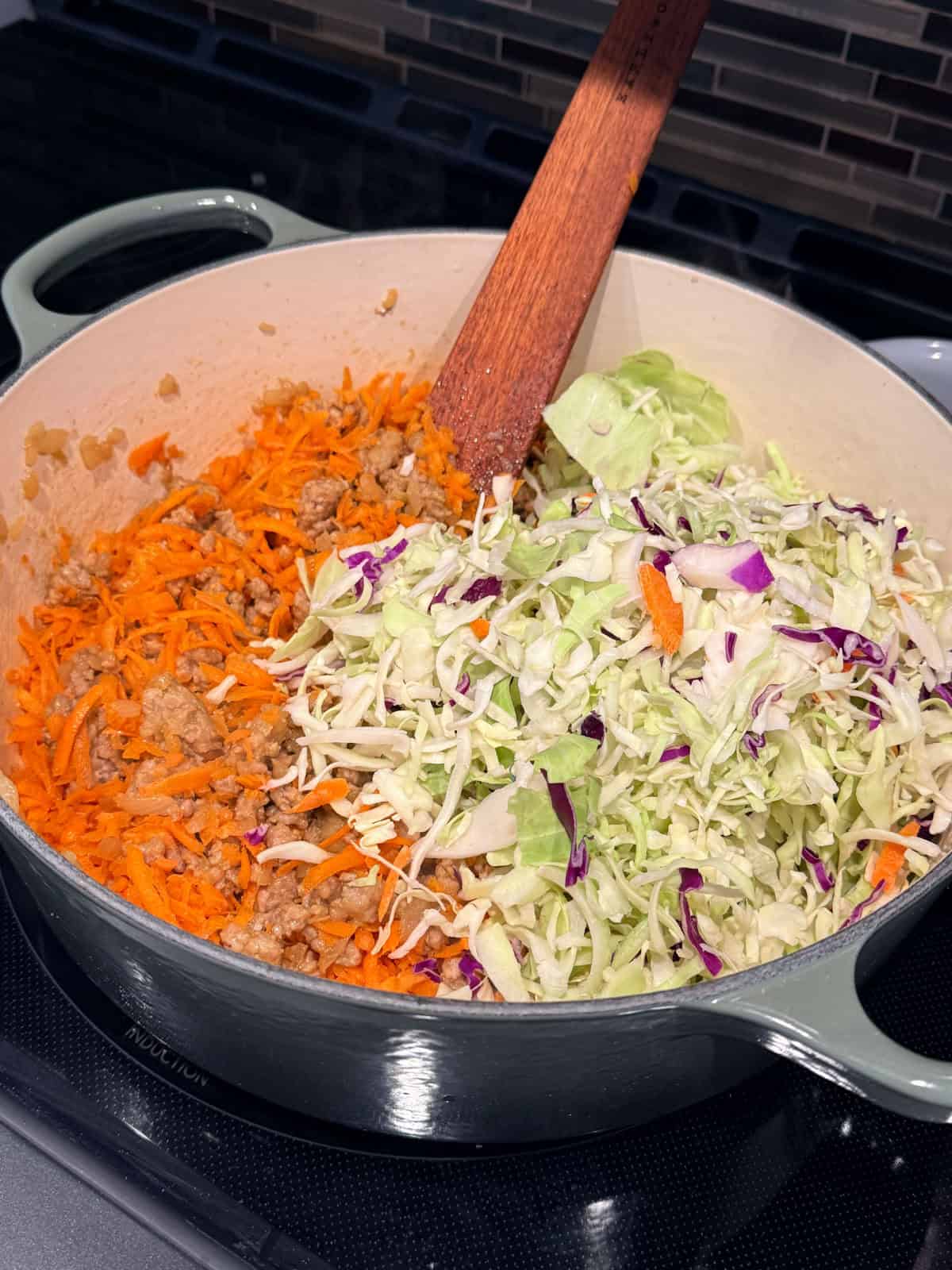 This easy egg roll soup has all the Asian-inspired flavors you love, with juicy ground pork simmered with tender cabbage, sesame, and ginger. Shredded carrots and cabbage added to browned pork in a Dutch oven.