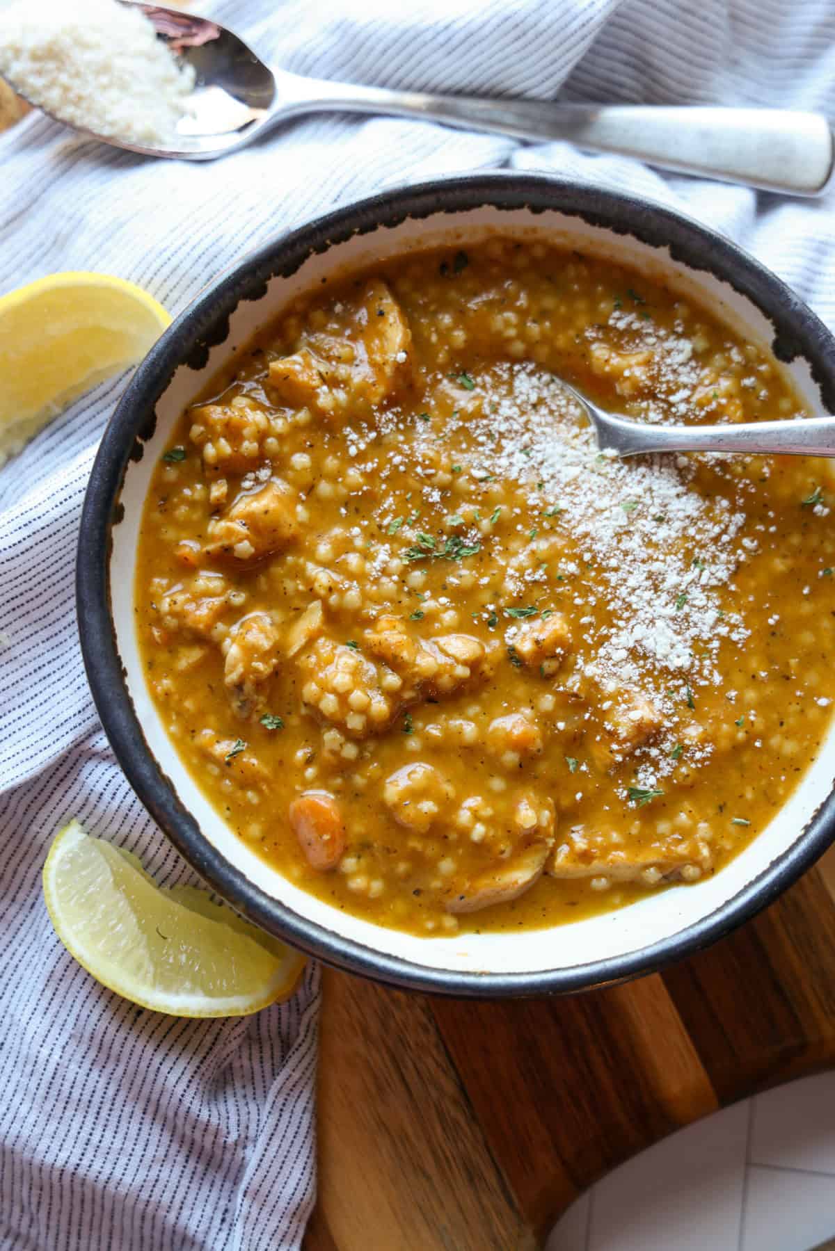 Discover how to make the easiest and most delicious Italian Pastina Soup that’s perfect for cozy nights, bursting with comforting flavors in every spoonful. Chicken pastina soup in a bowl surrounded with lemon wedges and sprinkled with cheese.