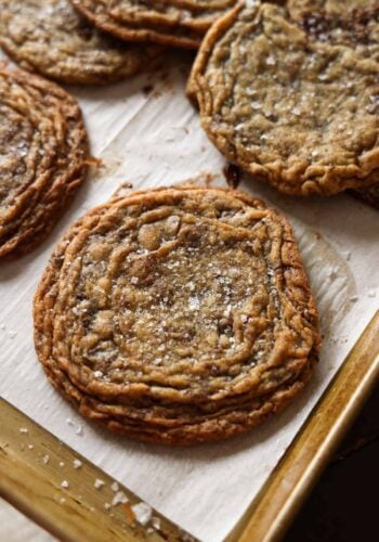 Giant Crinkled Chocolate Chip Cookies on a parchment lined baking sheet