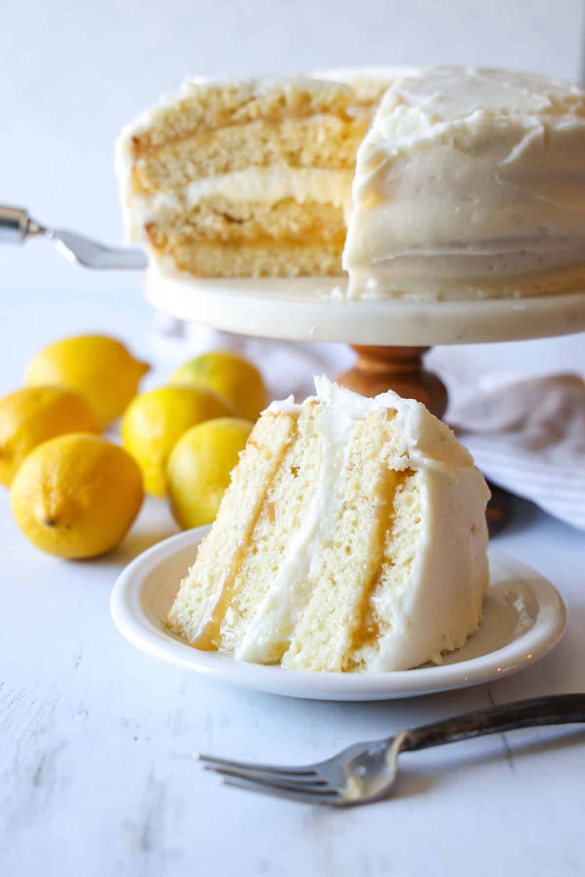 Lemon Cake slice with lemon filling and lemon frosting on a white plate