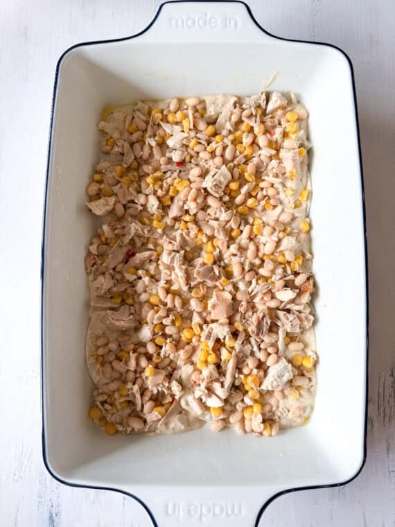 This Chicken Enchilada Casserole is going to earn a regular spot on your menu. It has all the cozy flavors of classic chicken enchiladas layered into an easy casserole A mixture of chicken, corn, and beans as a layer in the assembly of a chicken enchilada casserole