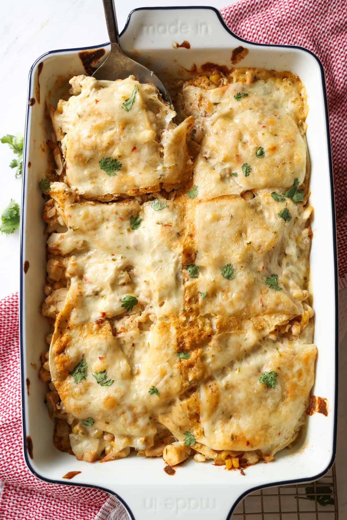 If your family loves Tex-Mex dinners, this Chicken Enchilada Casserole is going to earn a regular spot on your menu. It has all the cozy flavors of classic chicken enchiladas layered into an easy casserole that’s perfect for busy weeknights, meal prep, and freezer cooking. Chicken Enchilada casserole baked in a 9x13 baking dish.
