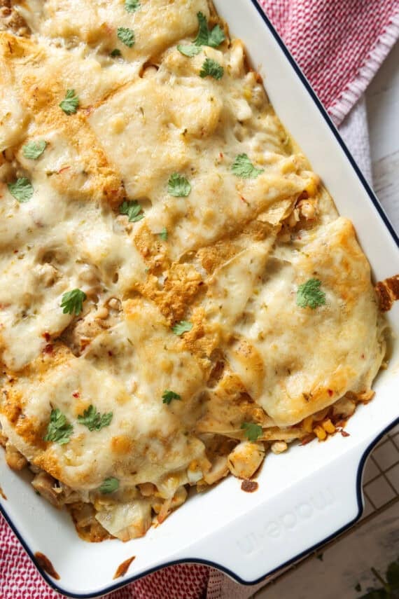 Chicken Enchilada Casserole in a white baking dish topped with melted cheese