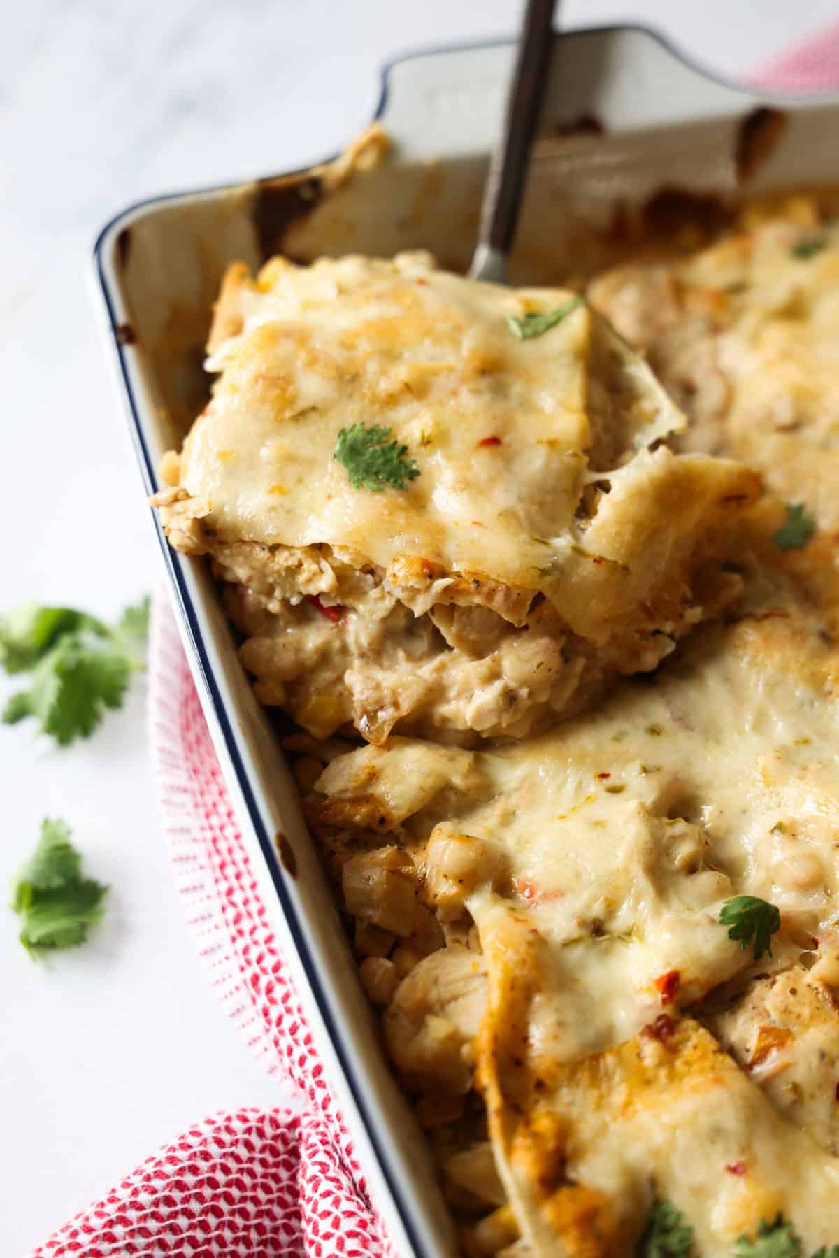 If your family loves Tex-Mex dinners, this Chicken Enchilada Casserole is going to earn a regular spot on your menu. It has all the cozy flavors of classic chicken enchiladas layered into an easy casserole that’s perfect for busy weeknights, meal prep, and freezer cooking. Creamy, cheesy chicken enchilada casserole baked in a white ceramic dish.