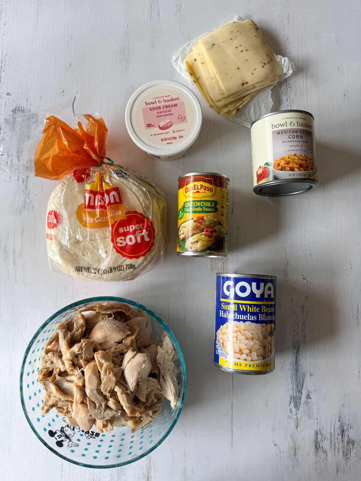 If your family loves Tex-Mex dinners, this Chicken Enchilada Casserole is going to earn a regular spot on your menu. It has all the cozy flavors of classic chicken enchiladas layered into an easy casserole that’s perfect for busy weeknights, meal prep, and freezer cooking. Ingredients for chicken enchilada casserole laid flat on a white board.