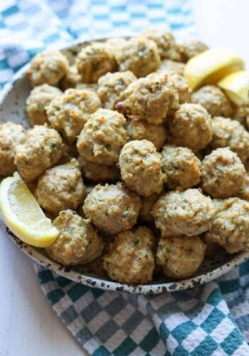 Chicken Meatballs in a bowl garnished with lemon slices