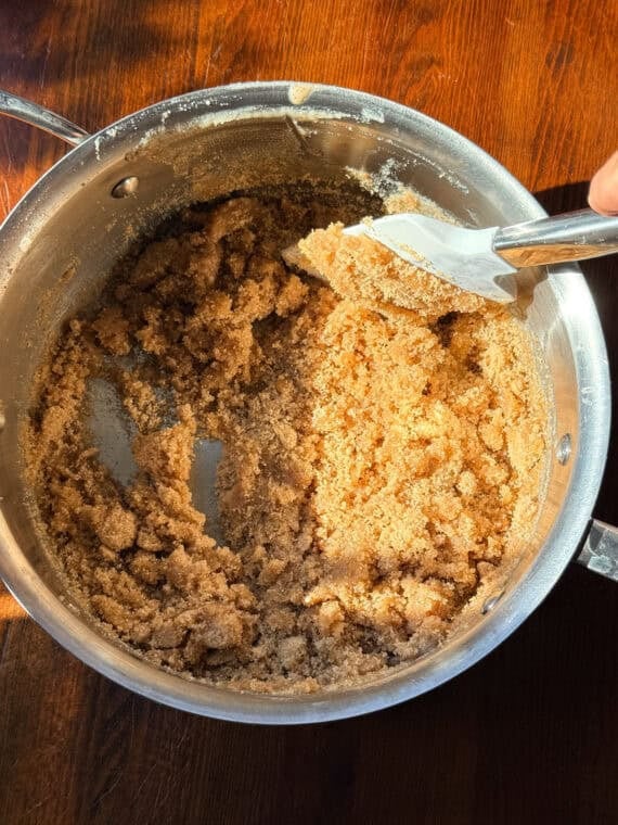 Stirring brown sugar into butter in a medium saucepan.