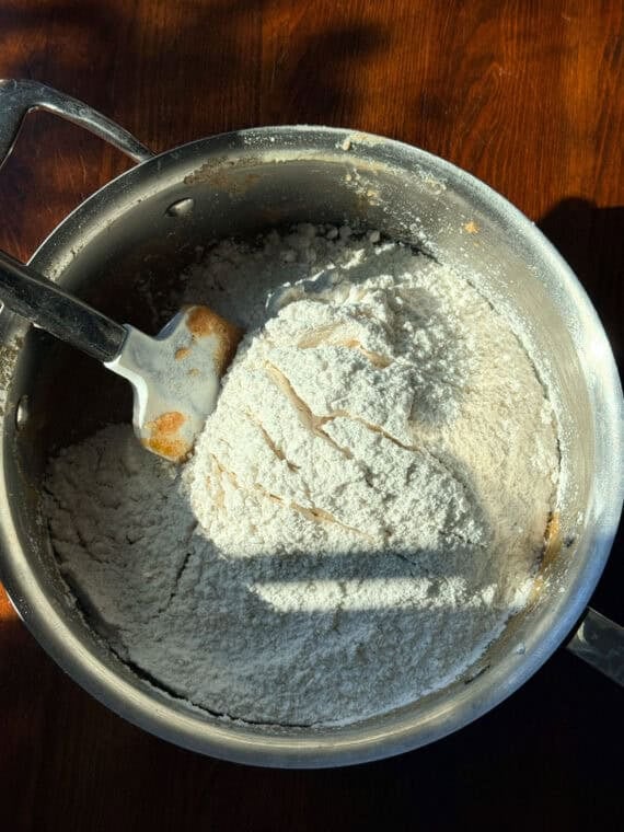 Mixing all purpose flour into cookie dough with a rubber spatula.