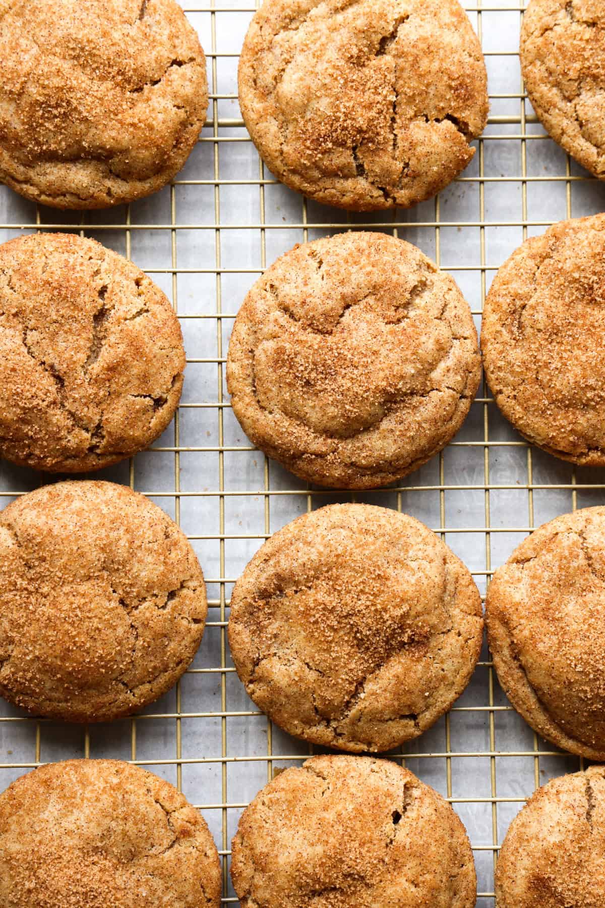 Cinnamon sugar coated churro cookies cooling on a wire rack.