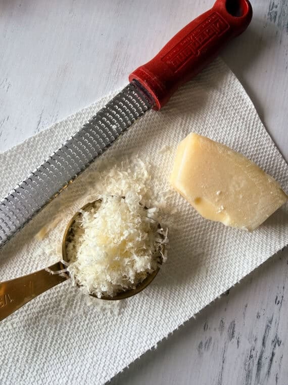 These juicy Pesto Chicken Meatballs are packed with fresh basil flavor, plenty of Parmesan cheese, and come together with just a handful of simple ingredients. They're baked instead of fried and ready in about 30 minutes making them an easy weeknight dinner or meal prep and packed with protein! Grated parmesan Cheese on paper towel with a microplane grater and Parmesan rind.