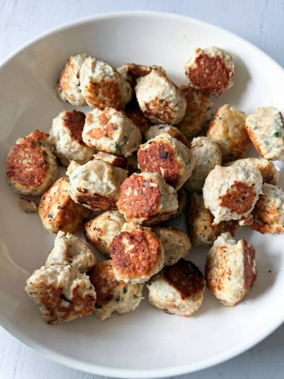 Browned chicken meatballs on a white plate.