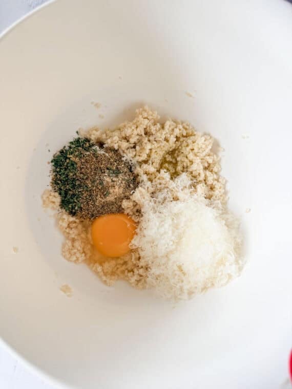 Breadcrumbs, milk, egg, Parmesan cheese, and seasonings in a white bowl.