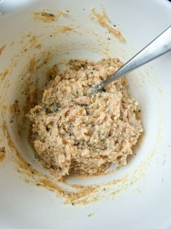 Meat mixture in a white bowl for chicken meatballs.