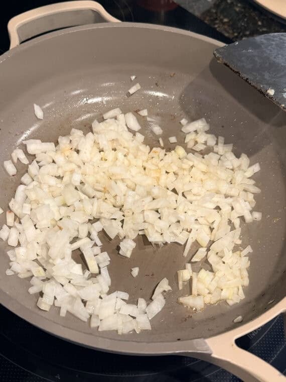 Cooking diced onions in a skillet.