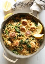Lemon orzo in a skillet with chicken meatballs and a wooden serving spoon in the skillet
