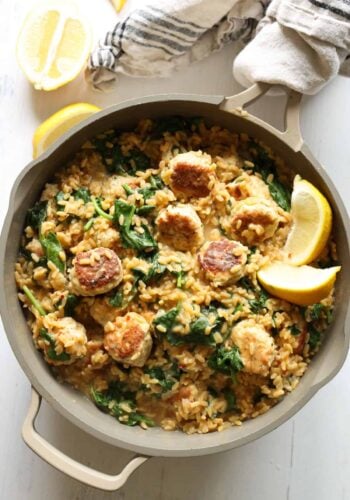 Lemon orzo in a skillet with chicken meatballs and a wooden serving spoon in the skillet