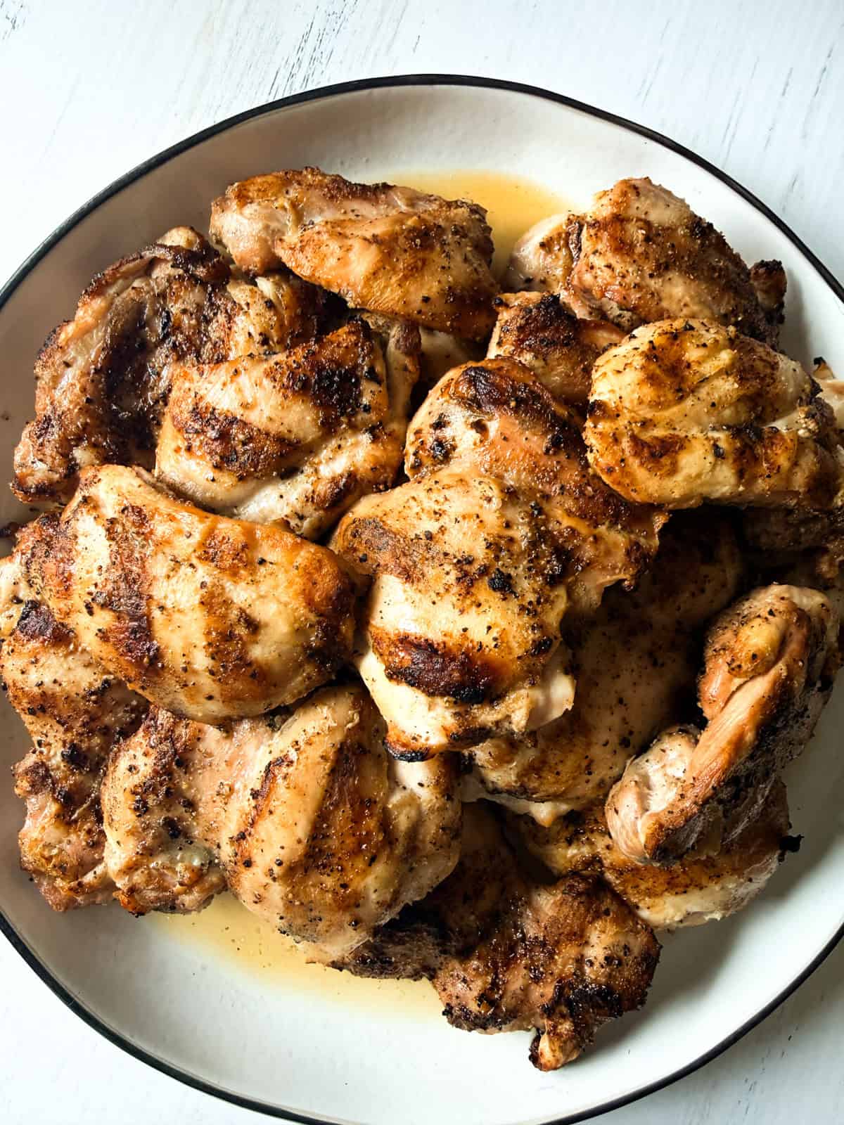 Grilled boneless chicken thighs on a white plate