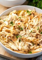 Shredded slow cooker Italian chicken in a large white bowl.