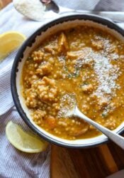 A bowl of creamy Italian Pastina Soup shot from above with parmesan cheese on top and a spoon