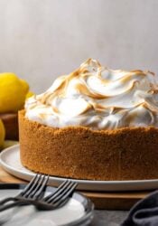 Side view of lemon meringue cheesecake with a toasted top on a plate.