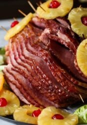 Pineapple-baked ham displayed with pineapples and cherries