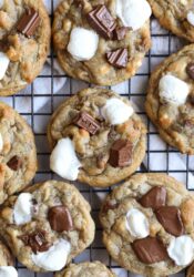 S'mores Cookies on a cooling rack with mini marshmallows and Hershey's chocolate