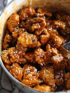 Sesame chicken in a bowl coated with sauce