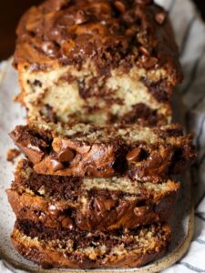 A loaf of chocolate marbled banana bread sliced to reveal the marbled interior.