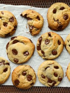 air fryer chocolate chip cookies on the air fryer rack with parchment paper