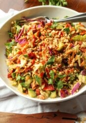 Rainbow crunch salad in a large white bowl, with a fork.